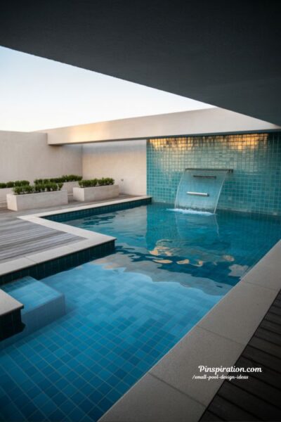 Glass accent small pool design with modern reflective surfaces and elegant light filled backyard aesthetic