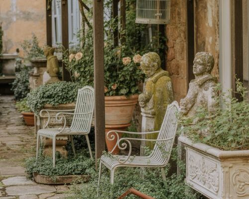 Antique garden decor with weathered iron chairs and mossy vintage stone accents