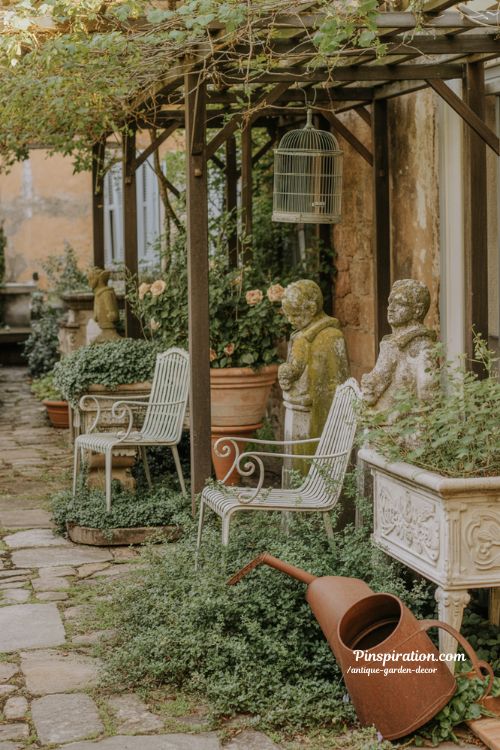 Antique garden decor with weathered iron chairs and mossy vintage stone accents