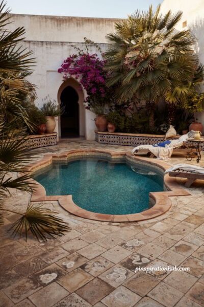 Classic quatrefoil natural swimming pool with terracotta coping hand painted tiles and a private courtyard garden
