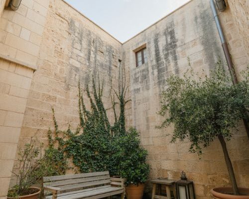 Courtyard garden with stone fountain olive trees and quiet enclosed Mediterranean home atmosphere