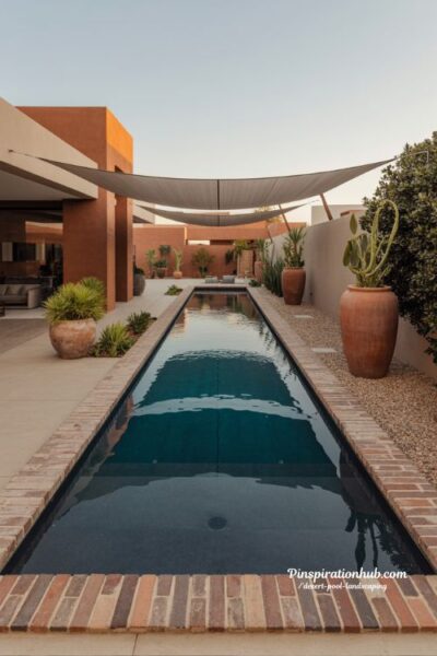 Desert lap pool with custom brick surround and terracotta planter landscaping