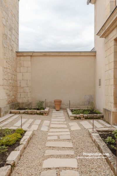 French courtyard garden ideas with stone and gravel texture contrast creating structured timeless courtyard design