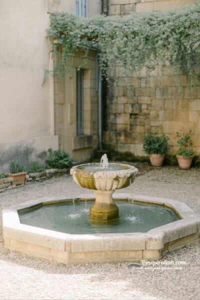 French courtyard garden ideas with stone fountain water feature creating calm peaceful courtyard energy and timeless garden design