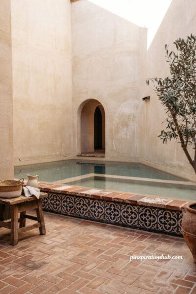 Glazed talavera tile accent border on spanish style pool steps with terra cotta coping