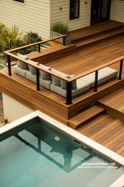 Raised above ground pool deck with cable railing and built in bench seating modern backyard design