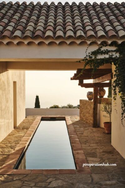 Spanish style pool structure with terracotta barrel tile roof and white stucco walls