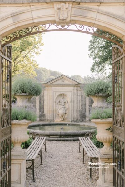 elegant french inspired garden with vintage stone fountain and lavender iron gate aesthetic
