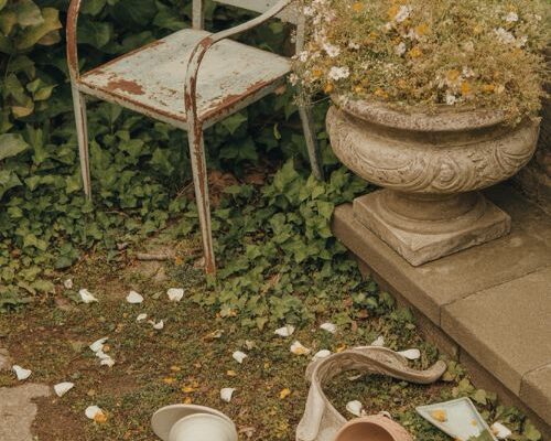 vintage garden decor ideas with rustic iron chair and wildflower stone urn aesthetic