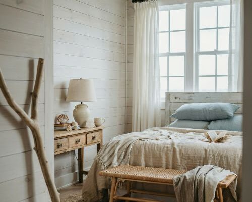Coastal cottage bedroom with layered linen bedding and soft seaside cottage decor