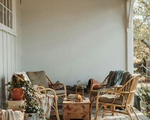 Cozy back porch patio ideas with warm rustic seating and layered greenery