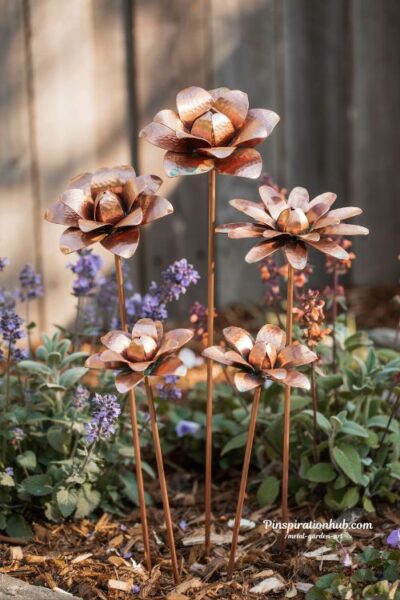 DIY copper flower garden stakes creating handcrafted botanical sculpture in a lush garden border