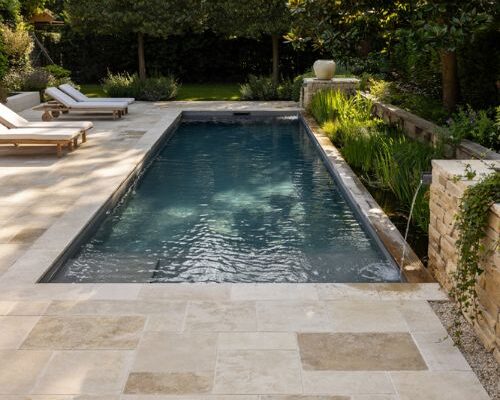Formal rectangular natural swimming pool design with integrated plant filtration zone on the side