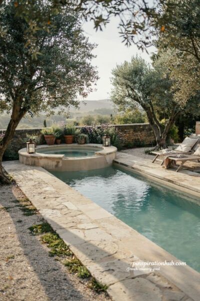 French country pool with semicircular spa and mature olive trees in a Mediterranean courtyard