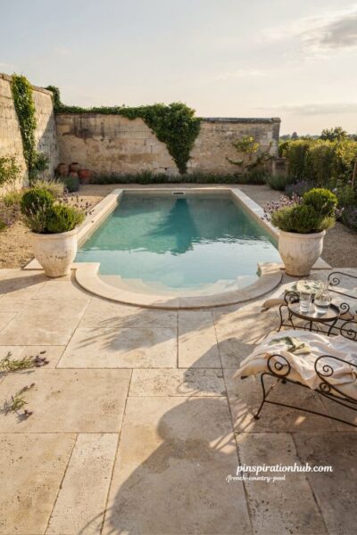 French country pool with white planters and graceful semicircular entry steps