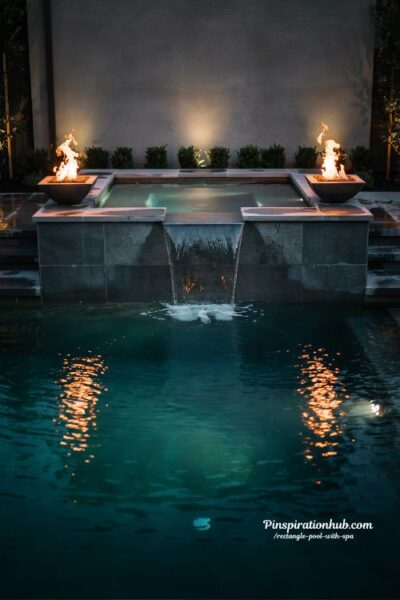 raised spa with fire and water bowls luxury backyard design with dramatic elemental lighting and modern resort atmosphere