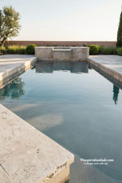 rectangle pool and spa with natural stone coping modern luxury backyard design using travertine bluestone and limestone textures