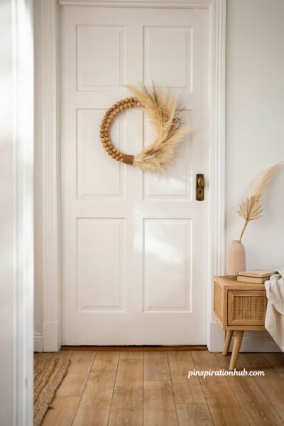 Boho pampas grass and raffia wreath on a wooden bead hoop for coastal autumn entryway decor