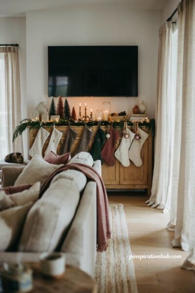 Christmas tv console with hanging stockings and cozy holiday living room decor ideas