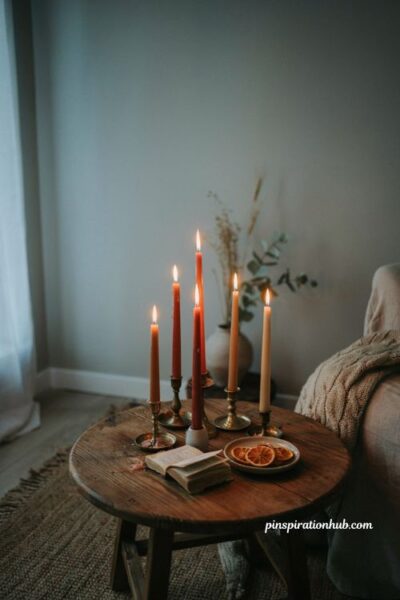 Cozy fall living room with grouped amber taper candles and glowing ambient candlelight on a wooden coffee table