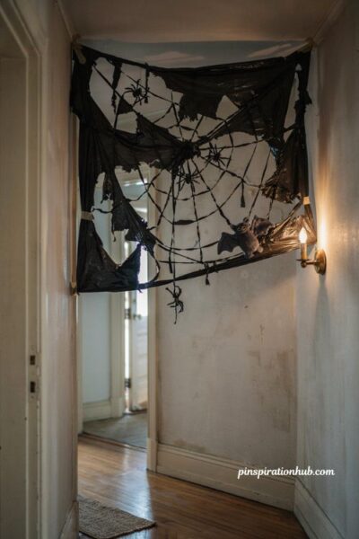 Creative halloween trash bag spiderweb decoration in a cozy hallway corner
