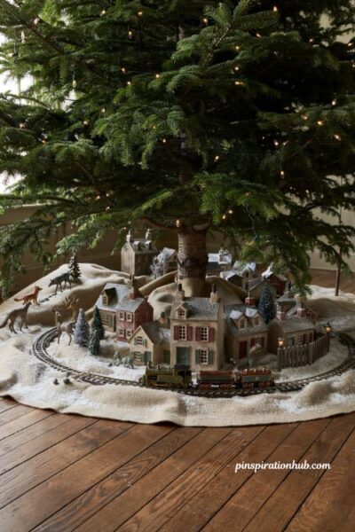 Detailed old-world miniature christmas village display set beneath a nostalgic vintage christmas tree with a toy train