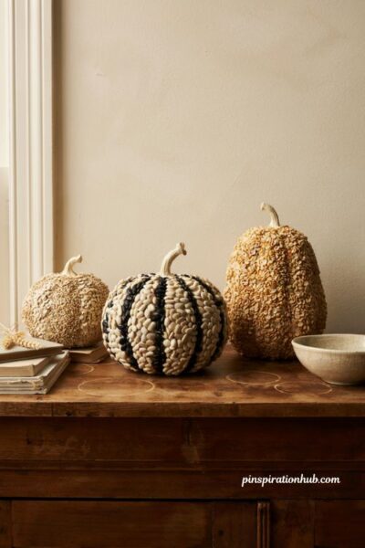 Diy dried bean textured pumpkins in a soft matte cream paint finish on a rustic farmhouse console table for fall decor