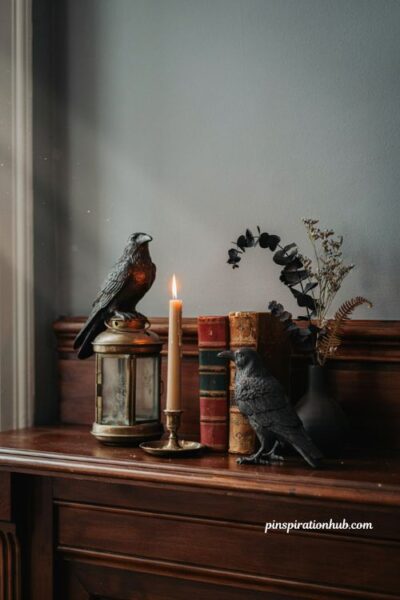 Metal raven figures perched on an antique lantern for moody gothic mantel halloween decor