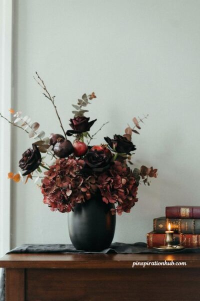 Moody and elegant dark floral arrangement in a black vase for halloween console table decor