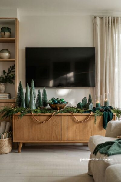 One color christmas tv console decor with forest green holiday vignette and elegant styling