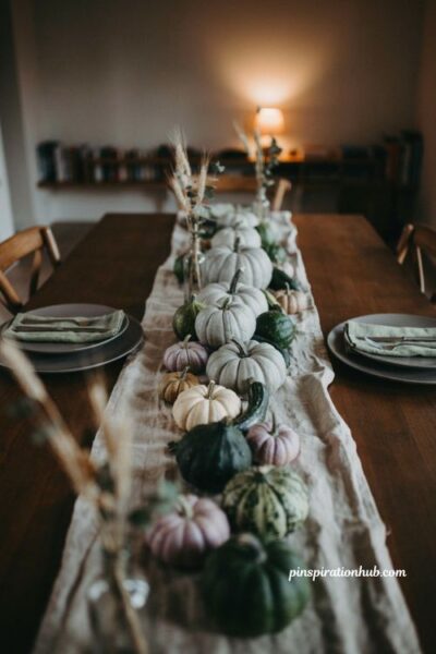 Citrus yellow pumpkin table decor with fresh green plants and low fall centerpiece