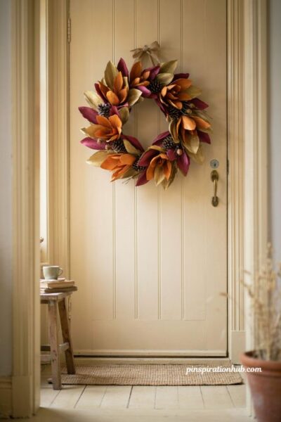Crepe paper magnolia pinecone and acorn wreath for front door with gold orange and magenta leaves
