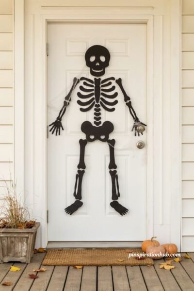 Diy friendly skeleton halloween door decoration with black paper bones and cobwebs