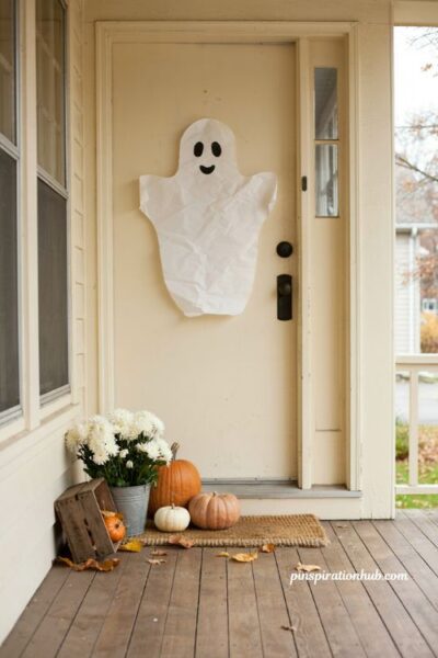 Diy ghost silhouette halloween door decoration with pumpkins and white mums