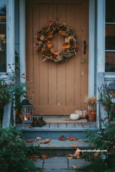Fall wreath with hidden string lights glowing on a cozy front door