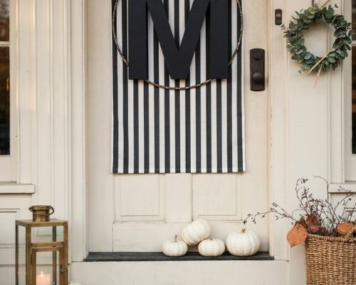 Monogram door display with subtle Halloween decor and pumpkins