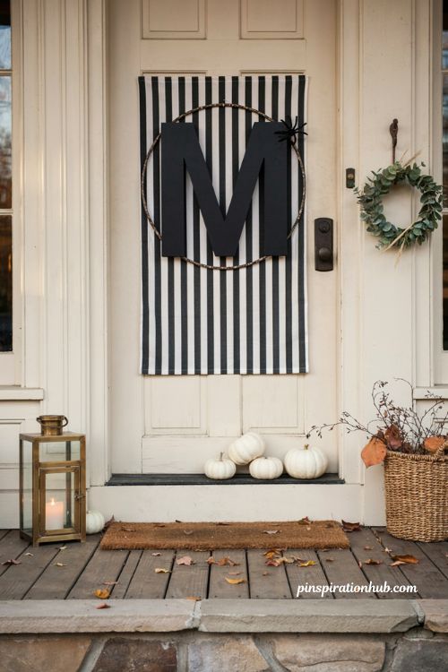 Monogram door display with subtle Halloween decor and pumpkins