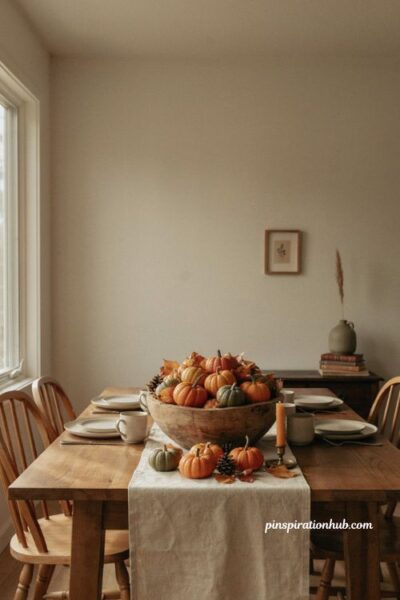 Simple fall centerpiece with mini pumpkins and pinecones
