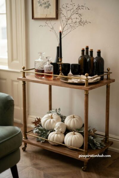 Spooky Halloween bar cart with black glassware and white pumpkins