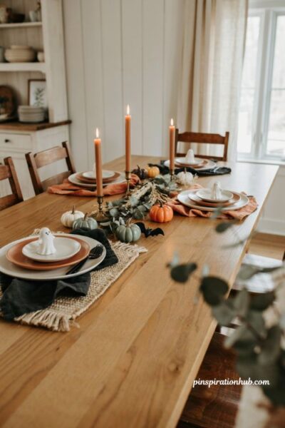 Cute Halloween decor dining table with pumpkins ghosts candles and greenery
