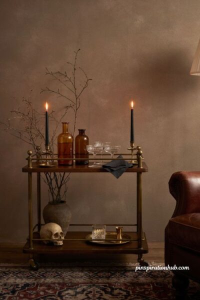Elegant Halloween bar cart with amber bottles and black candles