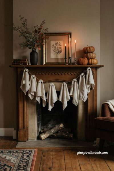 Elegant Halloween mantel with ghost garland and muted pumpkins