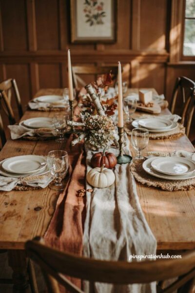 Fall dining table decor with a rustic burlap runner linen tablecloth and warm autumn accents