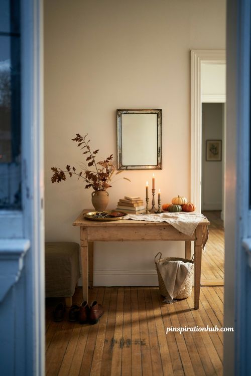 Fall entry table decor with pumpkins candles dried branches and warm autumn colors