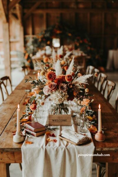 Fall wedding table decor with layered floral garland centerpiece and rustic welcome table styling