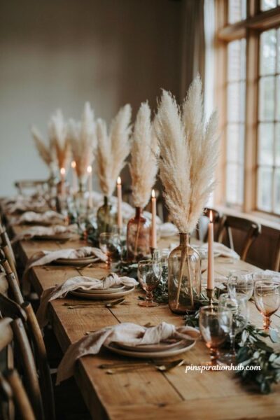 Fall wedding table decor with pampas grass tinted glass vases and greenery garland