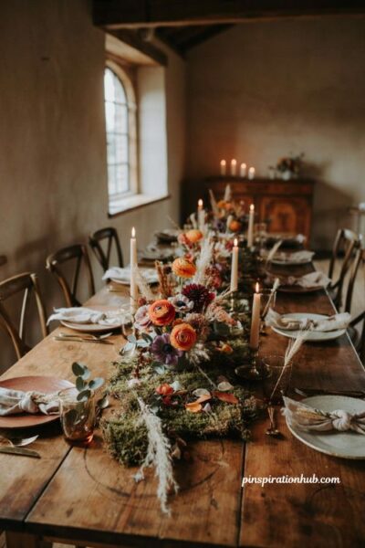 Fall wedding table decor with purple mauve orange flowers and mossy grass runner