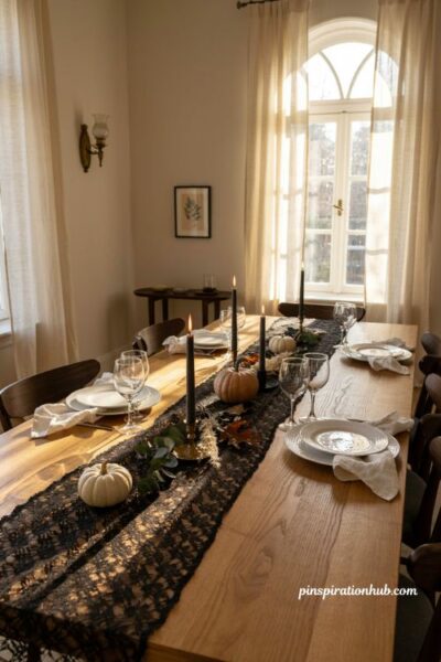 Halloween table runners with black lace candles and scattered pumpkins