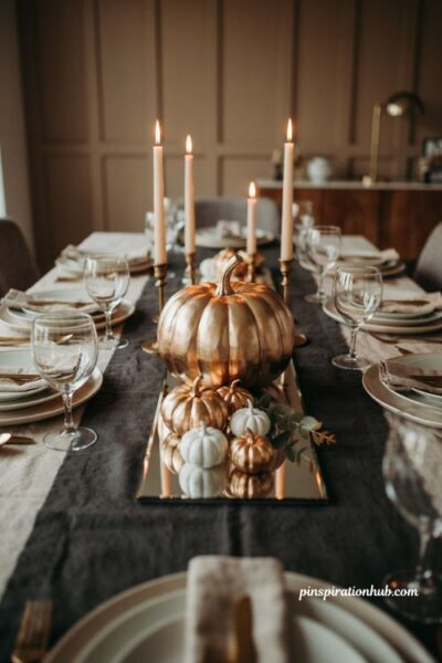 Metallic gold pumpkins on mirrored tray with white pumpkins