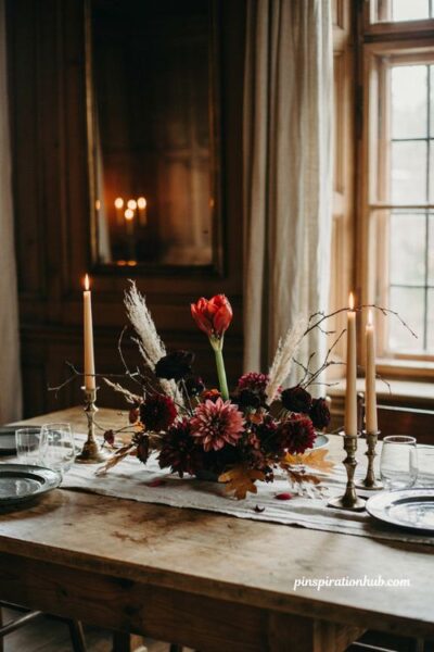 Moody floral Halloween centerpiece with burgundy dahlias and black roses